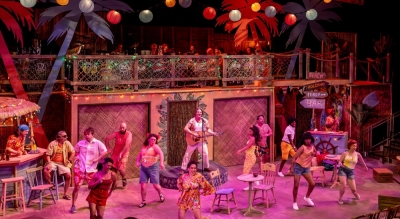 (center) Bryan Acker and members of the cast in JIMMY BUFFETT’S ESCAPE TO MARGARITAVILLE from Music Theater Works, now playing through November 1 in the North Theatre at the North Shore Center for the Performing Arts in Skokie.